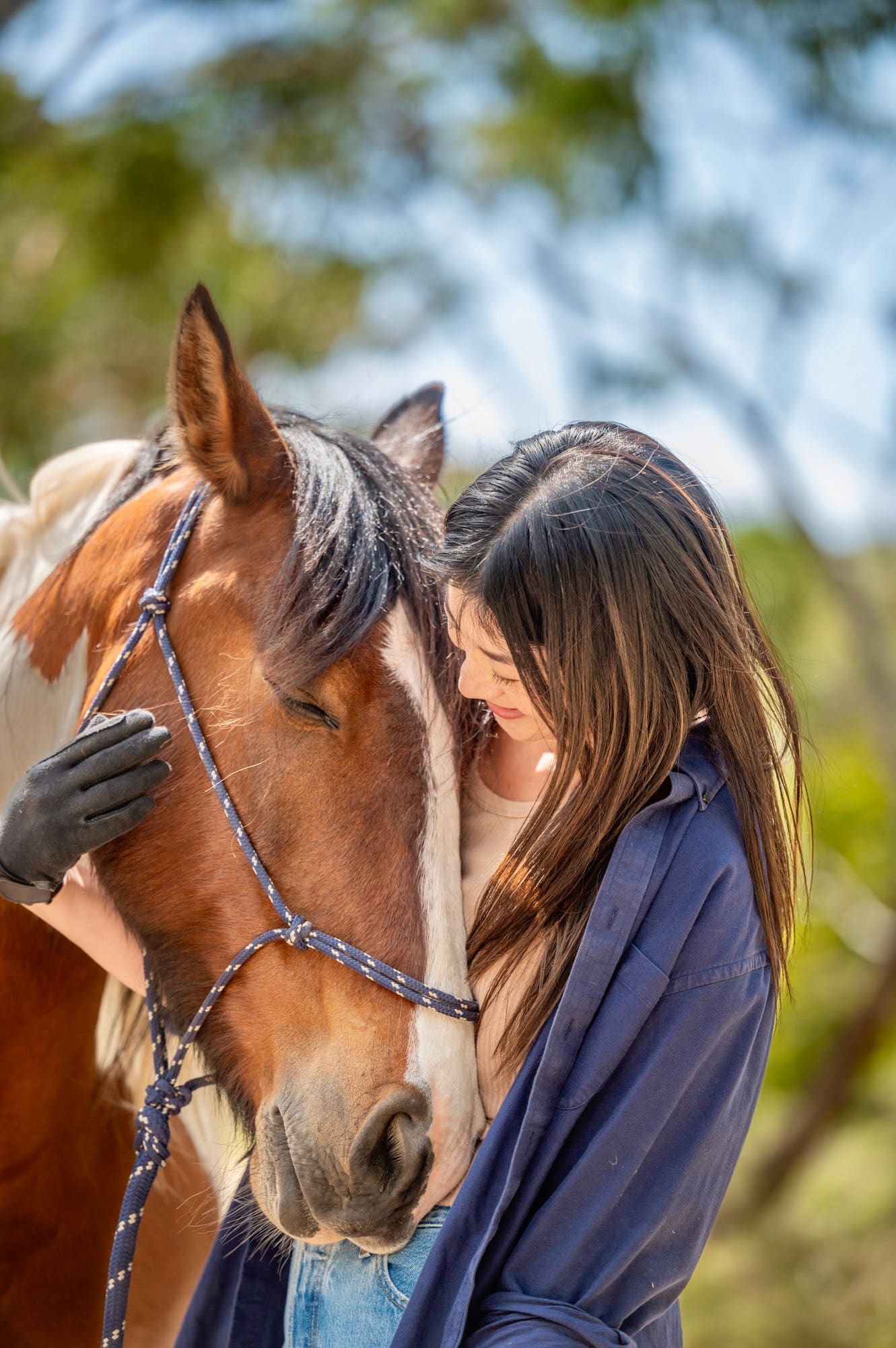 Smiling lady hugging her horse 