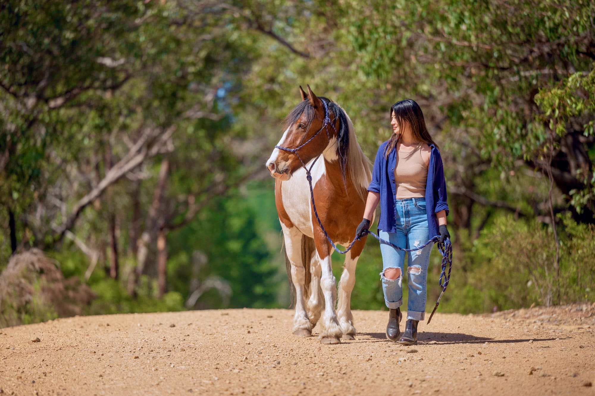 Relaxed lady walking with a horse in nature